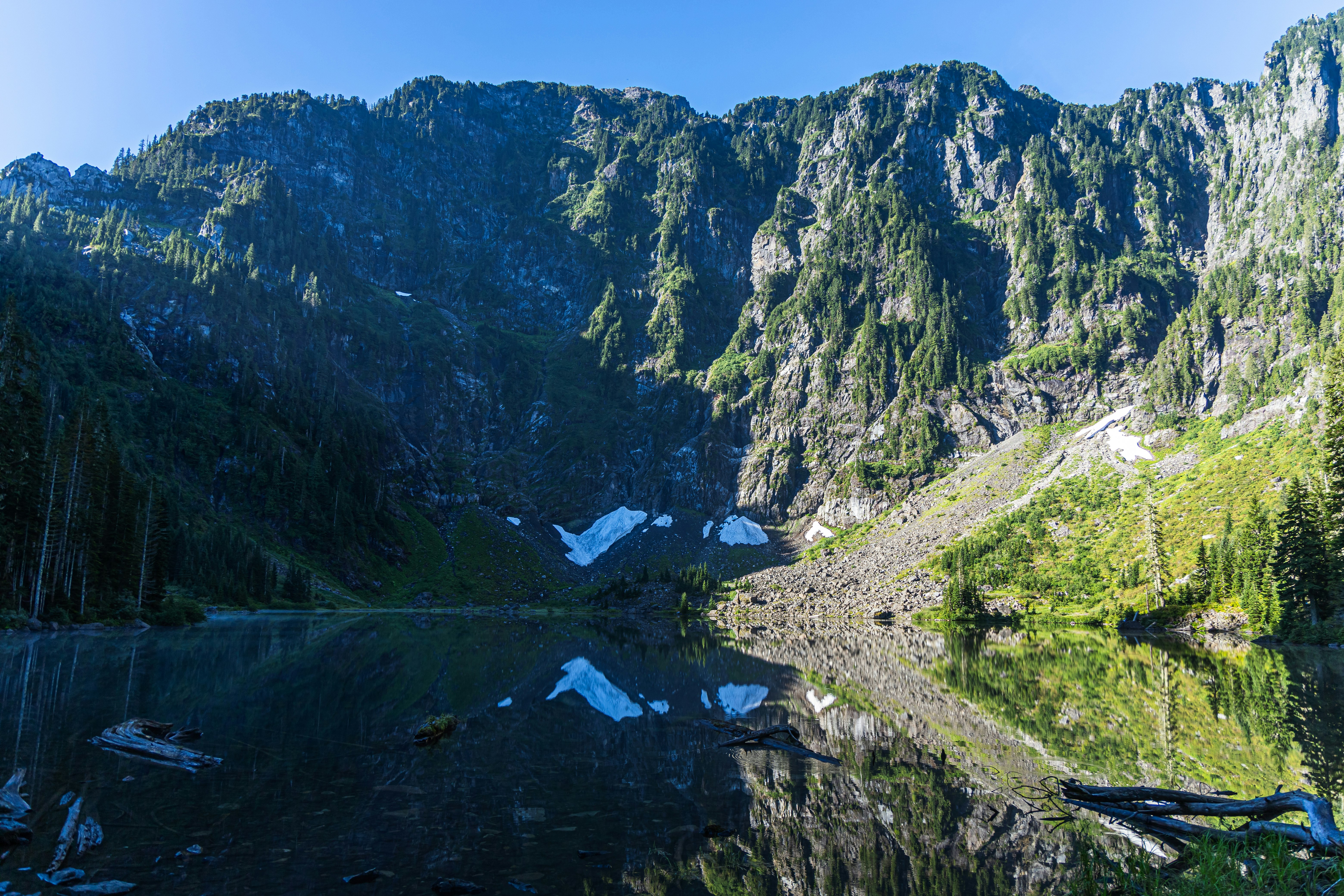 green and brown mountain beside river during daytime